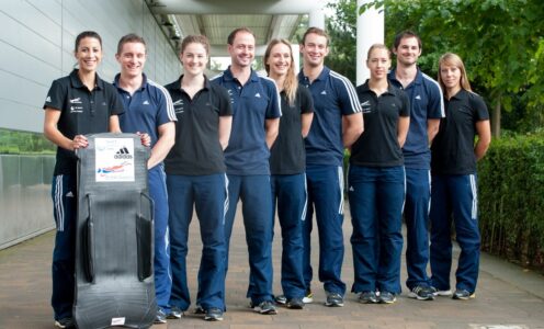 A group of British Skeleton athletes stood outside the University of Bath Sports Training Village. Shelley Rudman, on the left, is holding a skeleton sled.