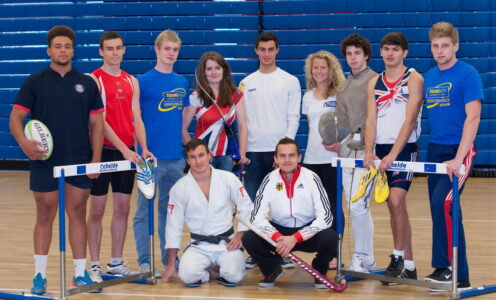 A group photo of student-athletes wearing different sporting kit in a sports hall.