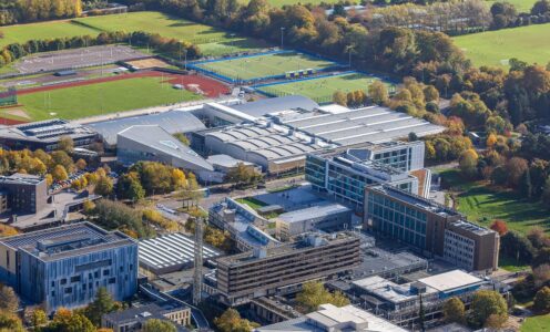 An aerial view of the University of Bath campus featuring the Team Bath Sports Training Village, outdoor athletics track and football, hockey and rugby pitches.