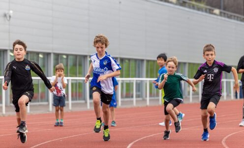 A picture of young people taking part in a Team Bath Tribe athletics camp at the Team Bath Sports Training Village in August 2024