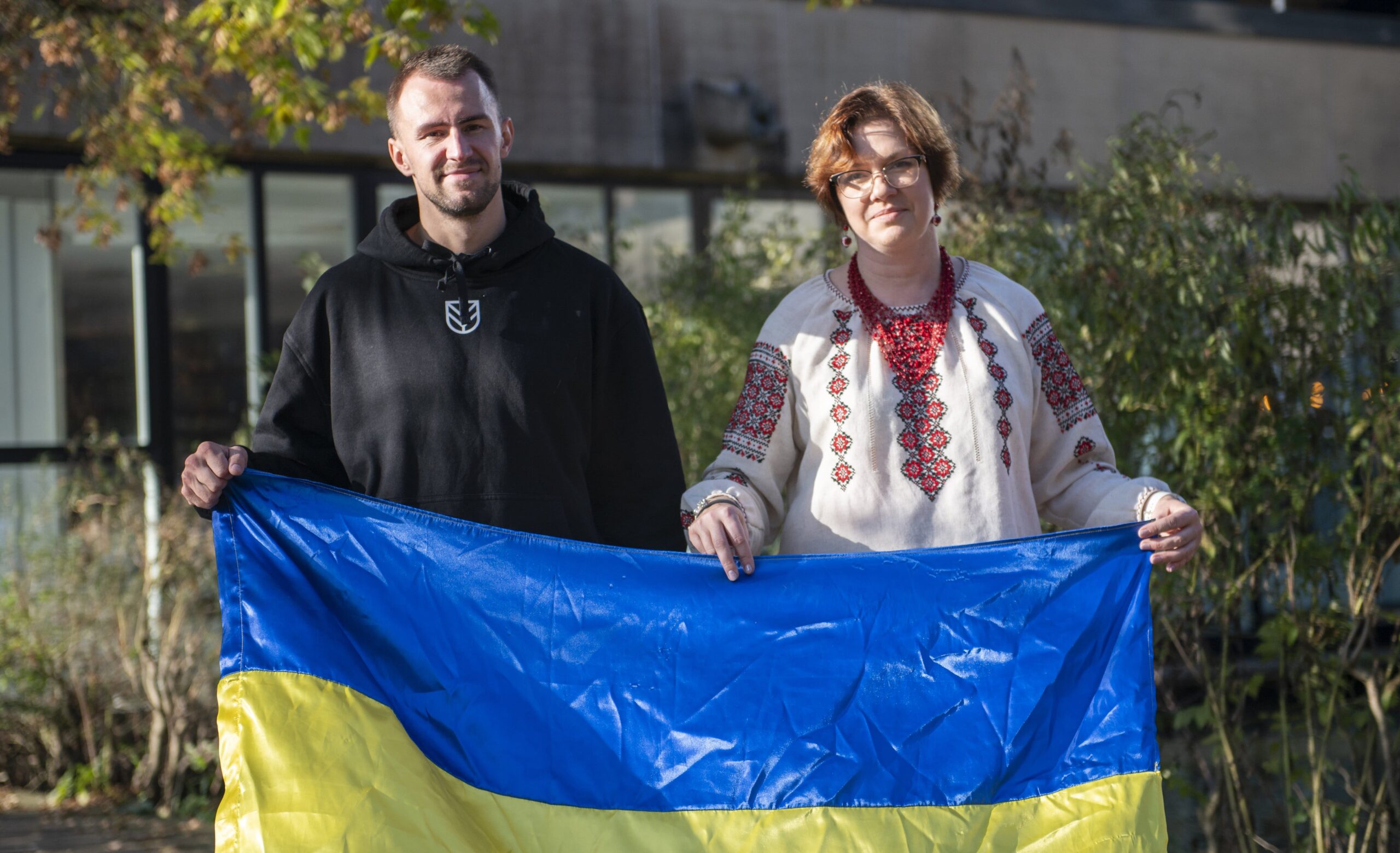 A picture of Ukrainian Parkour athlete Bohdan Kolmakov holding the Ukraine flag with Zhenya Shkil of the Friends of Oleksandriya charitable association