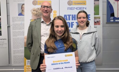 A photo of triathlete Isabelle Franco, the Team Bath Rengen Athlete of the Month for April 2025, flanked by University of Bath Director of Sport Stephen Baddeley (left) and Performance Sport Officer Sarah Collin. She is holding a certificate and the trio are standing in front of a board saying Athlete of the Month.
