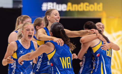 A photo of Team Bath Netball players hugging, smiling and celebrating after their NXT Gen League extra-time victory over Loughborough Lightning in May 2025.