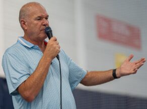 A photo of tennis coach David Sammel holding a microphone to his mouth as he addresses guests at the 2025 Team Bath Tennis Awards.