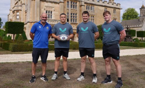 University of Bath Head of Rugby Aaron James with players Alfie Griffin, who is holding a rugby ball, Henry Mountford and Claudius Wheeler. They are stood out Farleigh House, Bath Rugby's headquarters.