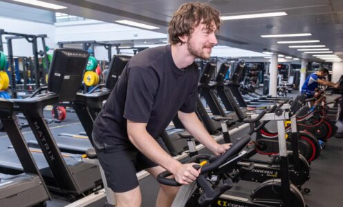 A gym user pedalling on an exercise bike in the Team Bath Gym