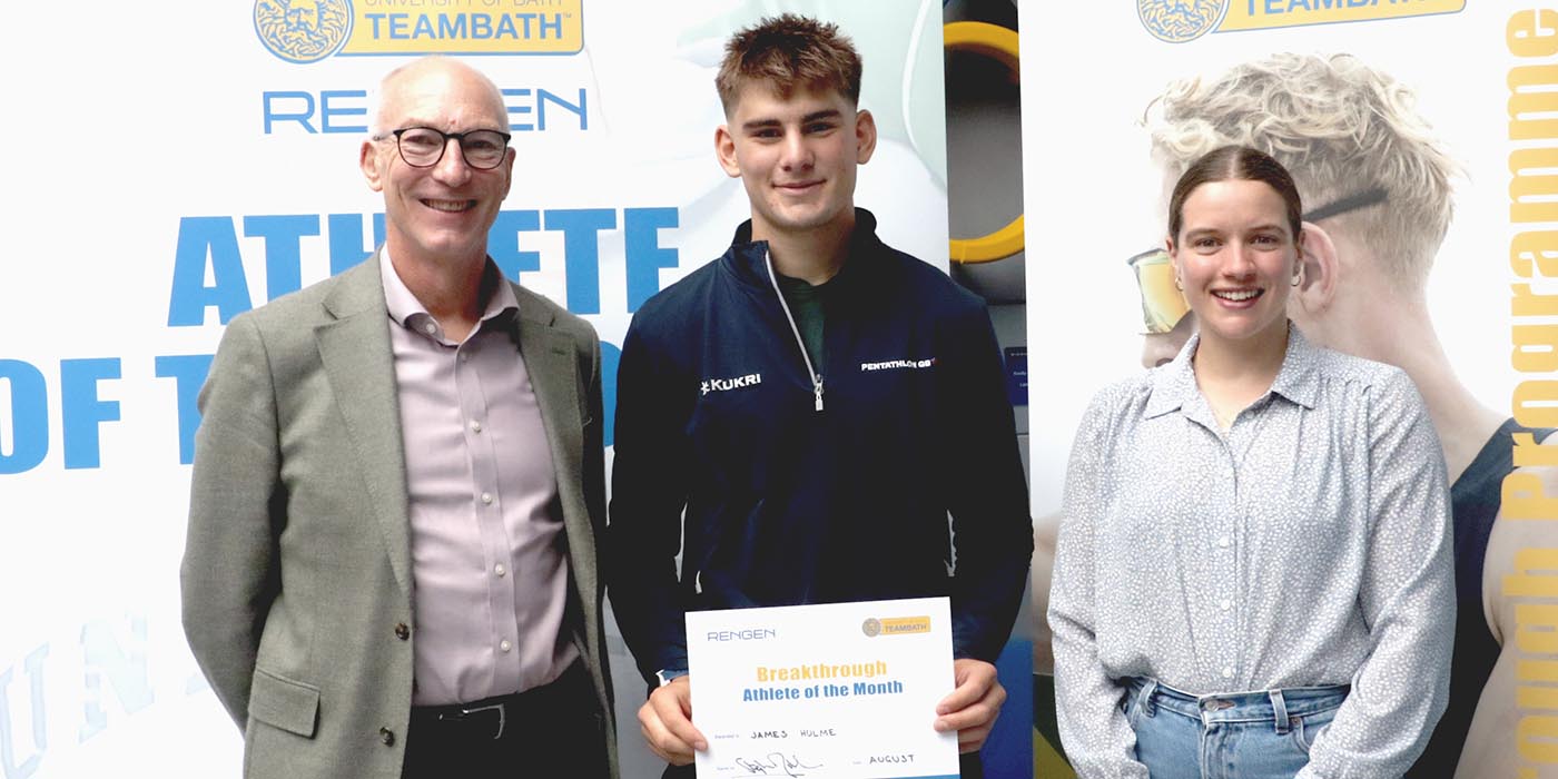A photo of Pentathlon GB's James Hulme, the Team Bath Rengen Athlete of the Month for August 2025, flanked by University of Bath Director of Sport Stephen Baddeley (left) and Performance Sport Officer Sarah Collin. He is holding a certificate and the trio are standing in front of a board saying Athlete of the Month.