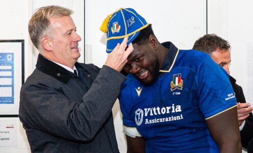 A man puts a cap on Enoch Opoku-Gyamfi's head after his senior Italy rugby debut