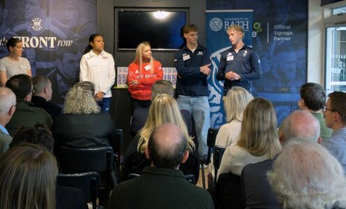 A quartet of University of Bath sporting scholars - (from left) Aleeya Sibbons, Kate Shortman, Jack Skerry and Charlie Brown - standing in front of a gathering of people during a reception.