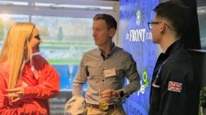 Three people talking at a reception. 