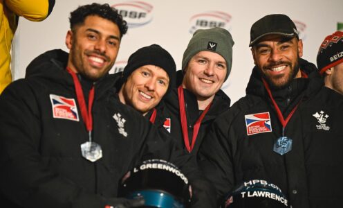 British Bobsleigh athletes (from left) Leon Greenwood, Greg Cackett, Brad Hall and Taylor Lawrence smiling on a podium after finishing fourth at the IBSF World Cup in Winterberg