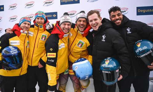Six bobsleigh athletes, four wearing yellow German coats and two wearing black British coats, on the podium at the 2026 European Championships