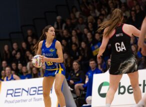 Team Bath Netball defender Orla Farrelly with ball in hand. Behind her is a full stand of spectators. 