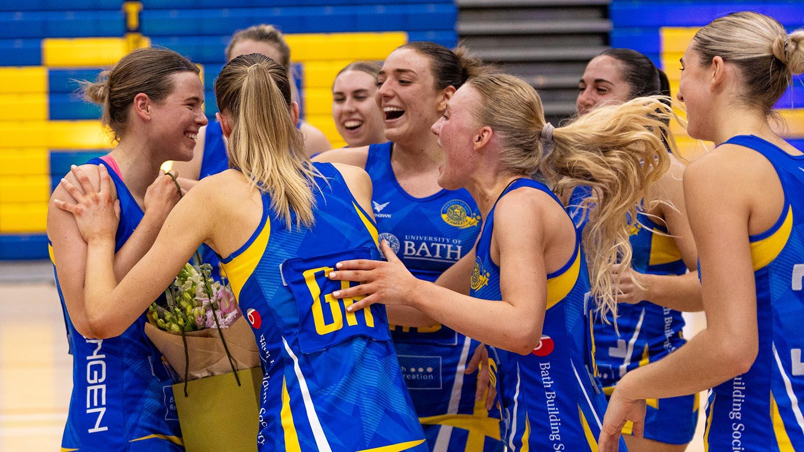 Sophie Siffre, holding a bouquet of flowers, is mobbed by her smiling team-mates after being named as MVP