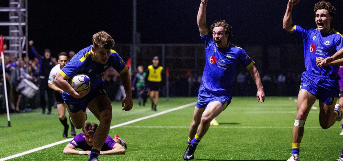 Two players raise their arms in celebration as team-mate Harry Walker prepares to dive across the line for a Bath try