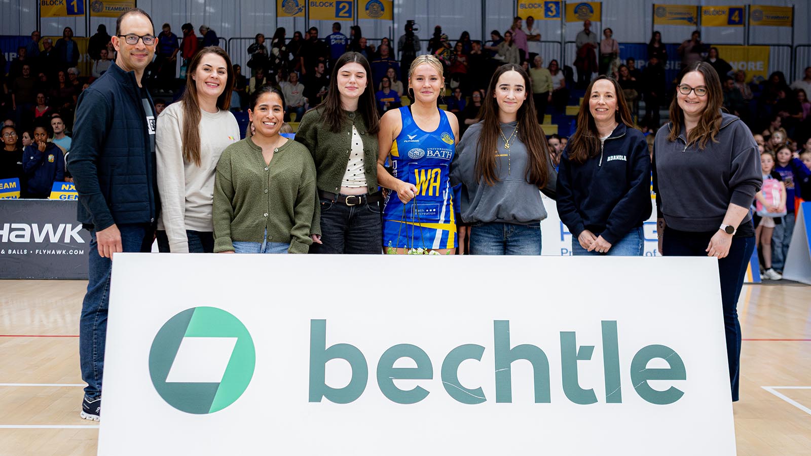 Most Valuable Player Lowri Windsor (centre) standing behind a white Bechtle sponsors board with representatives of the company