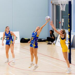 Team Bath Netball defender Lottie Robinson reaches out her left hand at full stretch to intercept a pass towards a Leeds Rhinos attacker