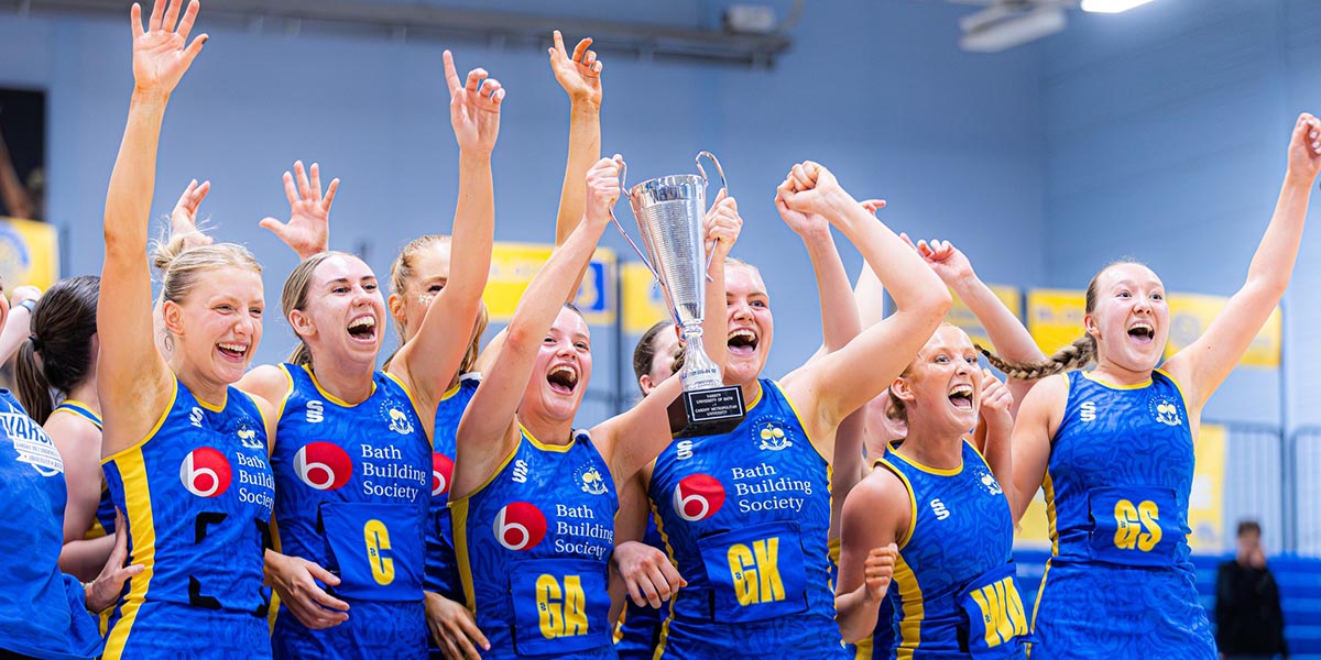 University of Bath Netball Club players holding aloft the Varsity trophy and celebrating