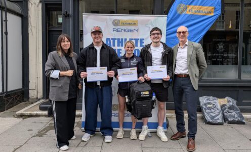 (From left) Rengen's Sarah Baker, Max Pearce, Poppy Clark, Christian Ryan and University of Bath Director of Sport Stephen Baddeley standing in front of an Athlete of the Month pop-up banner. The three student-athletes are holding Athlete of the Month certificates.
