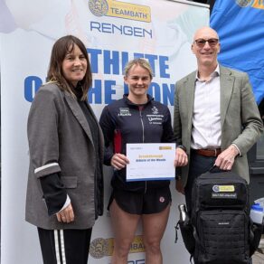 (From left) Rengen's Sarah Baker, pentathlete Poppy Clark and University of Bath Director of Sport Stephen Baddeley standing in front of an Athlete of the Month pop-up banner. Poppy is holding a certificate and Stephen is holding a Built for Athletes backpack.