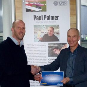Paul Palmer shaking hands with University of Bath Director of Sport Stephen Baddeley and receiving a framed certificate after being inducted into the University of Bath Hall of Fame for Sport