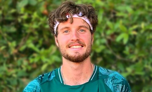 A profile picture of Team Bath Tennis player Toby Samuel with a green hedge behind him