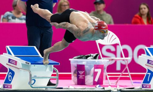 Swimmer Jacob Peters diving into a pool from the blocks