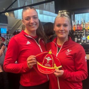 Poppy Tydeman (left) presents a red Wales Netball cap to Lowri Windsor