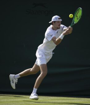 Team Bath Tennis player lines up a shot on a grass court at Wimbledon