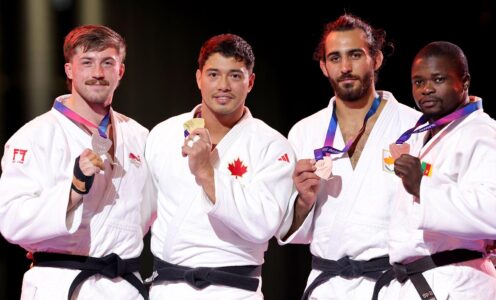 Four judoka on a podium holding up their medals