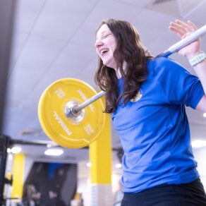A woman lifting a weight in a gym