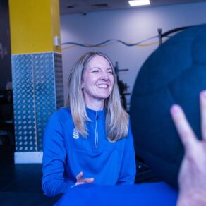 A woman in a blue Team Bath top in a gym environment