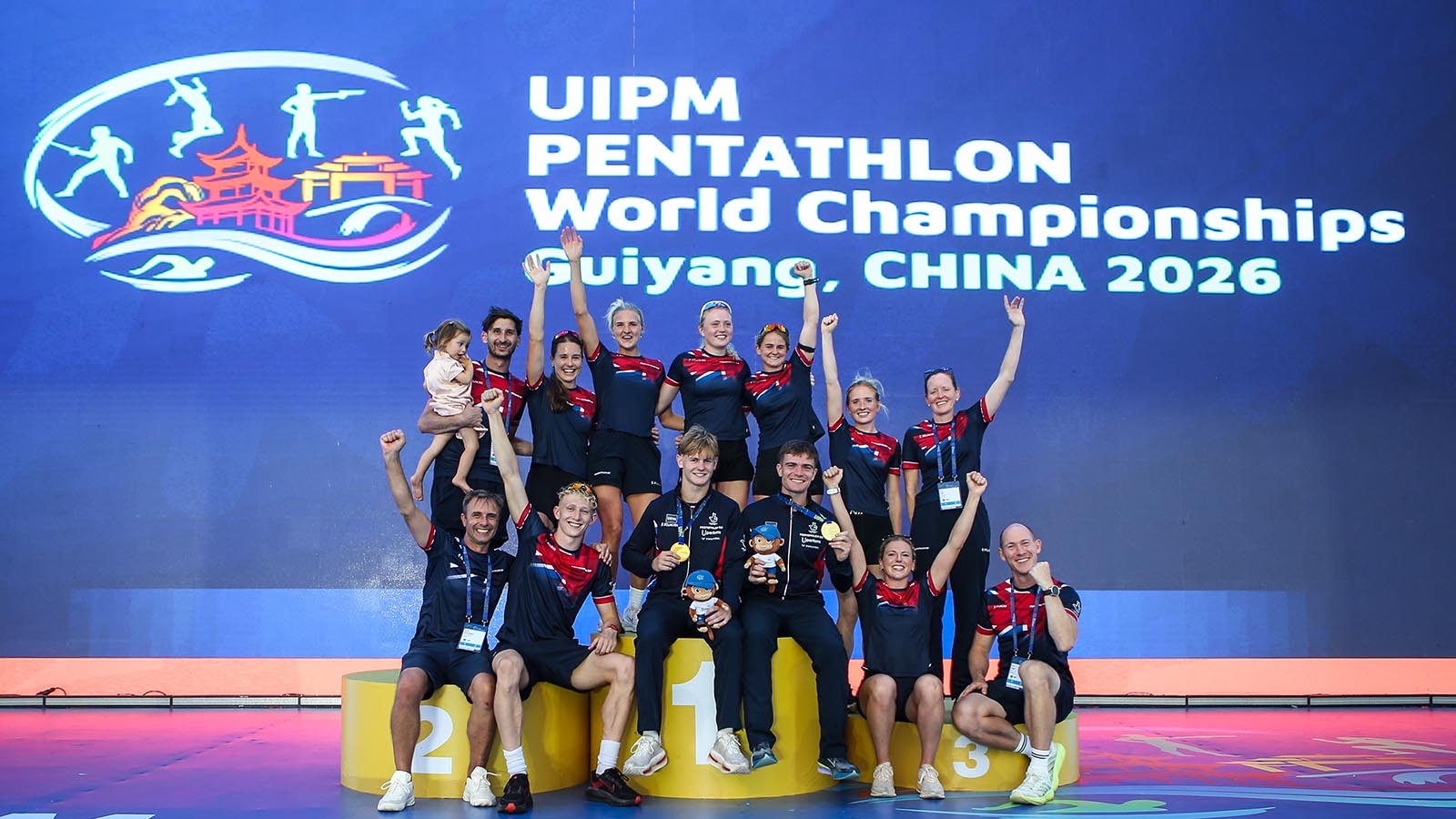 The Pentathlon GB squad and support staff celebrate with Ross Charlton and Seb Forrest, front centre, who are wearing gold medals around their necks