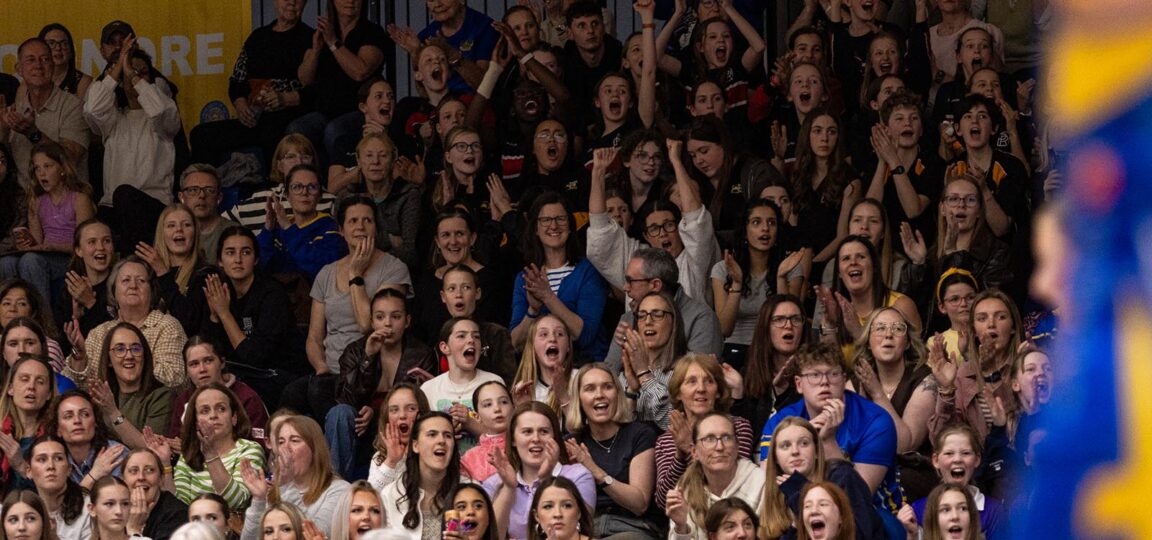 A crowd of netball fans in a full stand